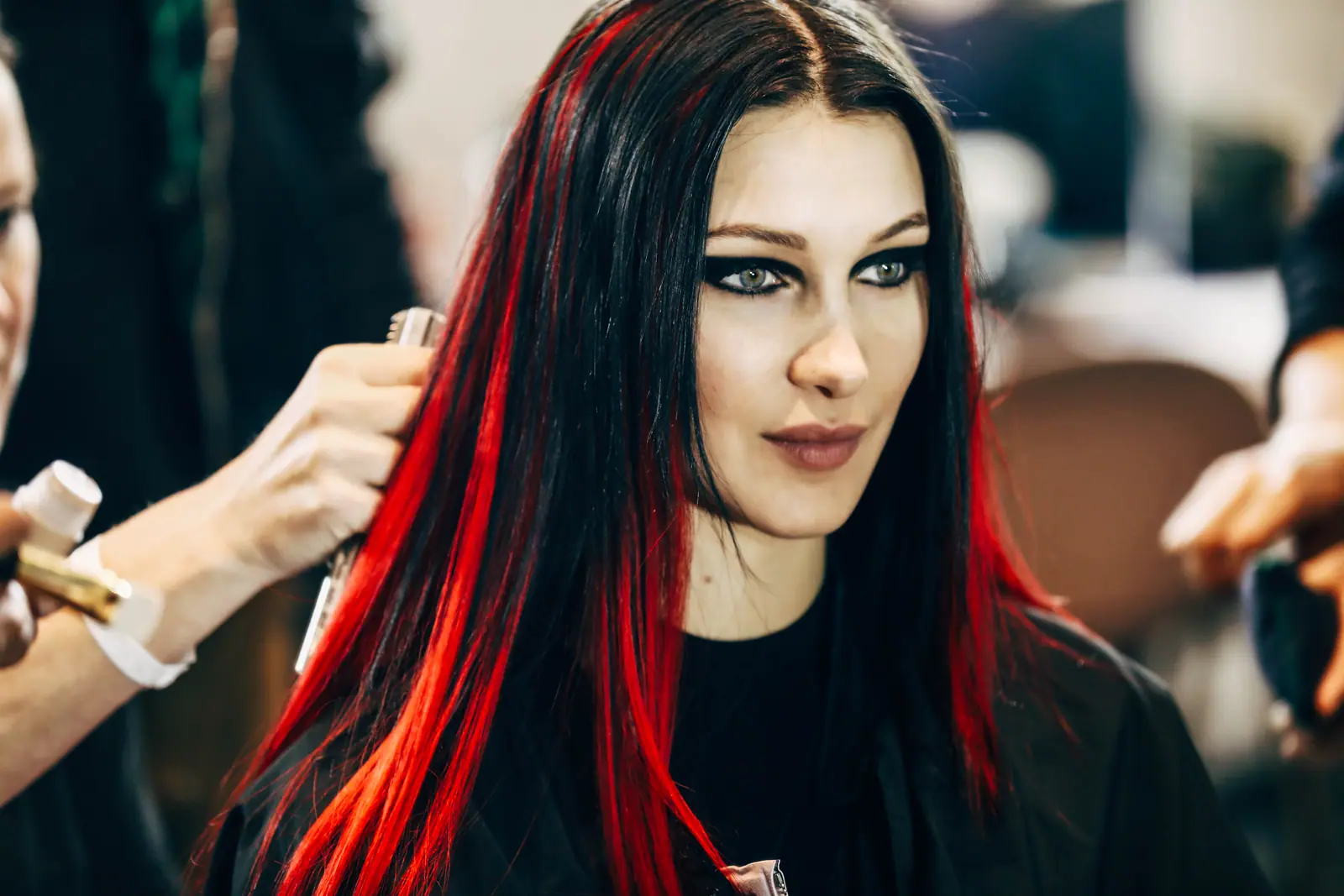 Bella Hadid with red-streaked hair during backstage make-up