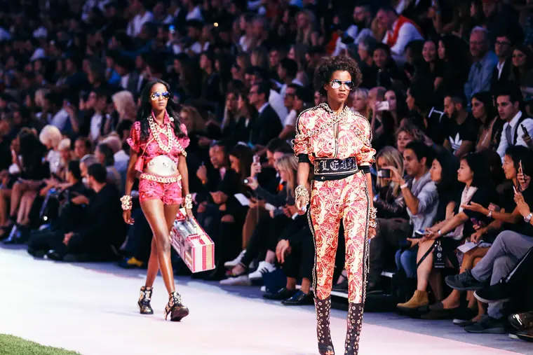 Model walking the runway in front of a packed audience