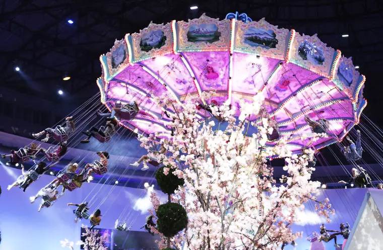 An illuminated carousel set piece glowing above the runway