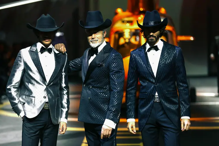Models in suits and hats on the runway