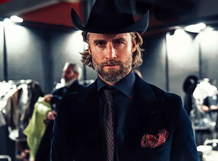 Bearded model in a cowboy hat and suit, backstage