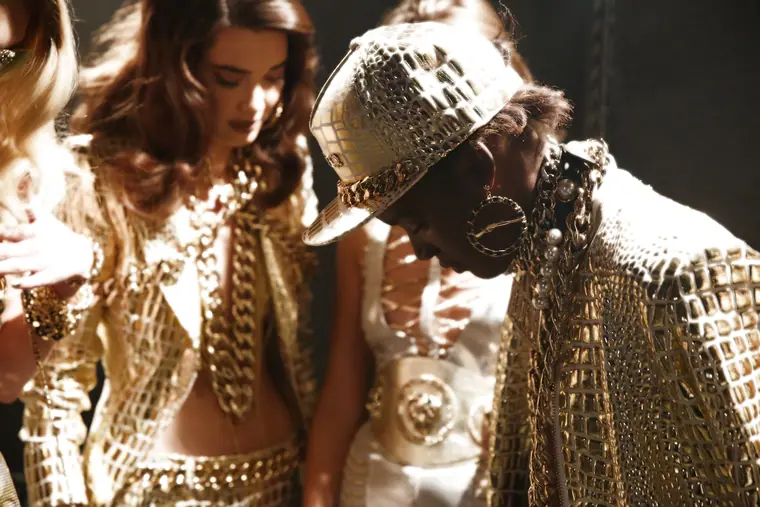 Models in embellished jackets and caps, backstage