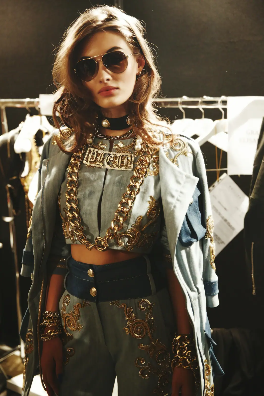 Model in denim and chains with mirrored sunglasses