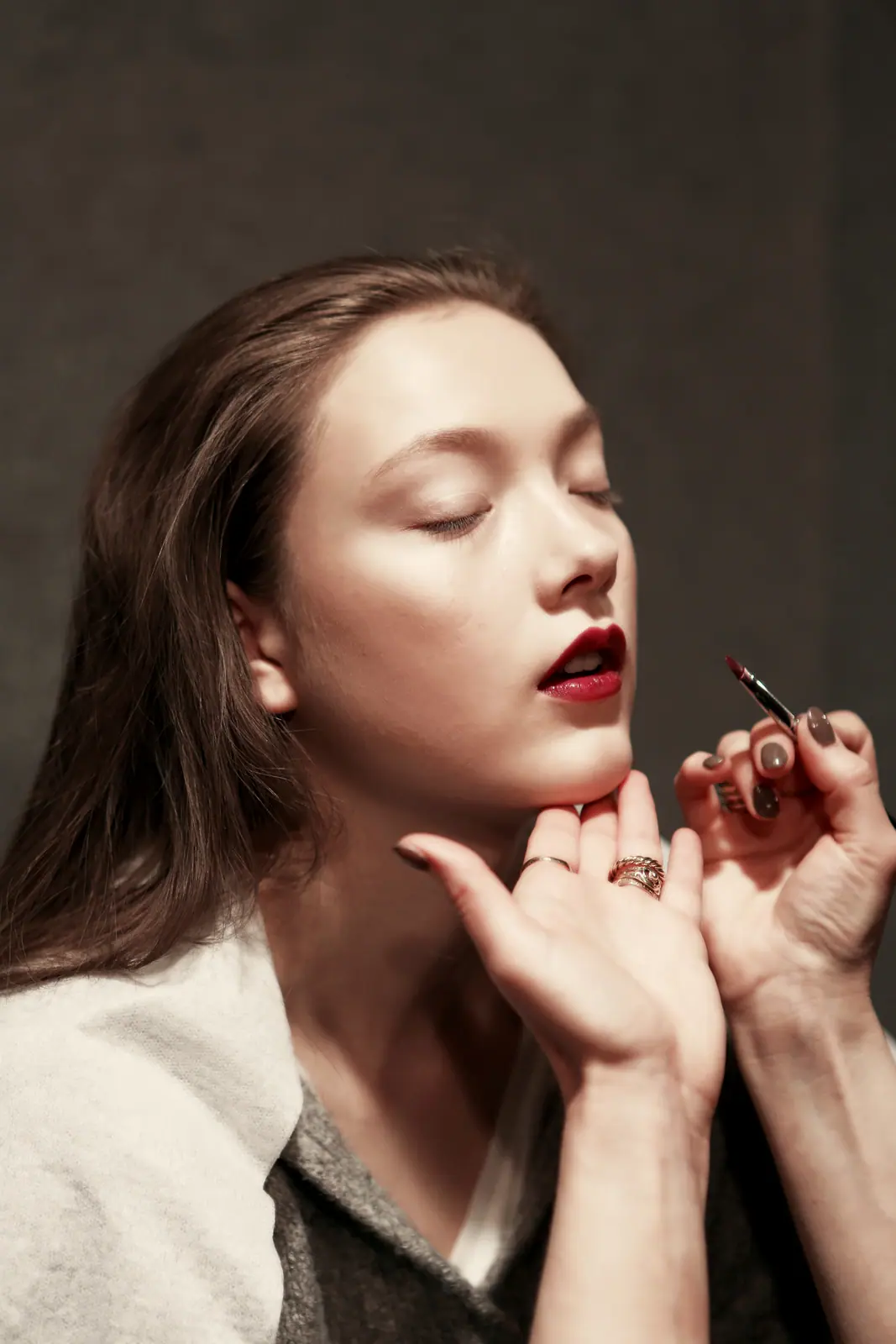Model with red lips resting her chin on her hands