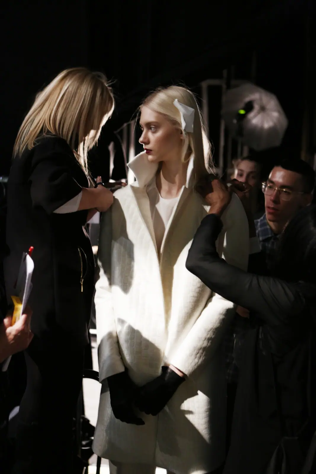 Model in a white tailored look being prepared backstage