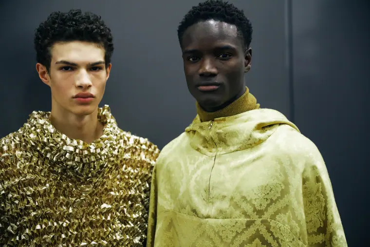 Two models, one in gold knit, one in a yellow hoodie