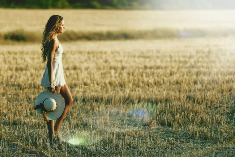 Elisha in a wheat field holding a hat