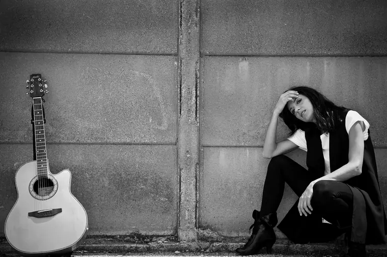 Micol Martinez with a guitar, black and white