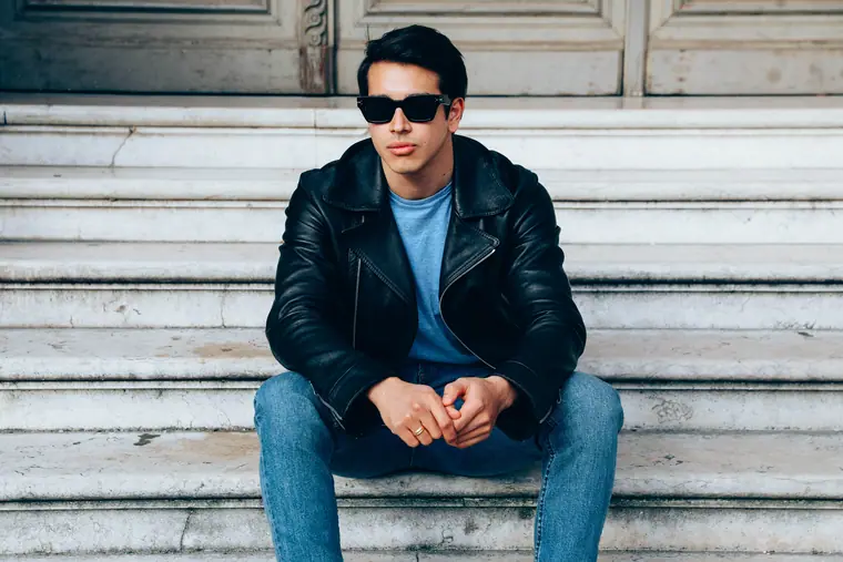 Man in sunglasses and a leather jacket on steps