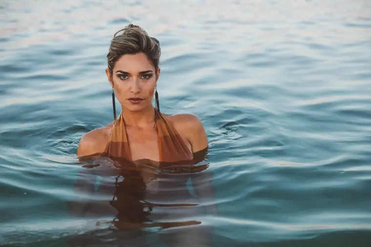 Woman standing shoulder-deep in the sea